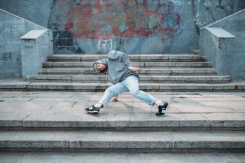 Male rapper posing on the street, urban dancing. Modern dance style