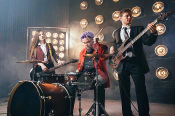 Bearded drummer in red suit, performing on the stage with lights, vintage style. Musical performer with colorful hair, drum instrument