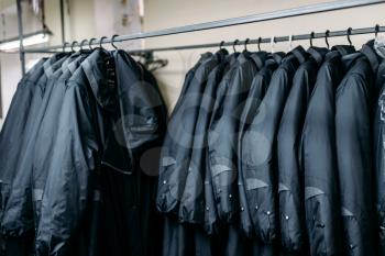 Row of jackets on a hangers, clothing store, sewing factory or dress fabric. Clothes on a racks
