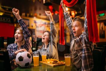 Football fans with scarf watching match and raise their hands up in sports bar. Tv broadcasting, young friends leisures in pub, favorite team wins