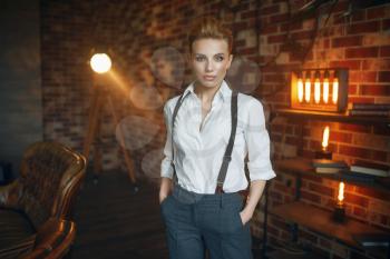 Business woman in strict clothes poses in studio, retro fashion, gangster style, mafia. Vintage lady in office with brick walls