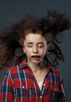 Strong wind blowing on woman's face, funny emotion. Powerful air flow blows on female person, black background