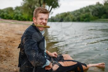 Office worker in torn suit sitting on the beach on desert island. Business risk, collapse or bankruptcy concept