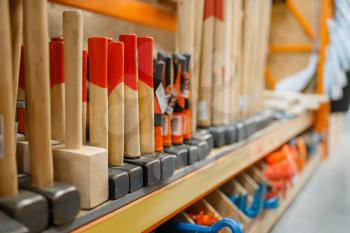 Hardware store assortment, shelf with hammers, nobody. Building materials and tools choice in diy shop, rows of products on racks