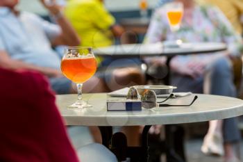 Tourists drinks beer in street cafe in old European tourist town. Summer tourism and travels, famous europe landmark, popular places for travelling