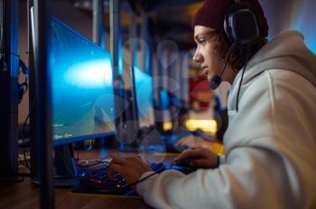Two young gamers in headsets play in video game club. Virtual entertainment, e-sport tournament, cybersport lifestyle