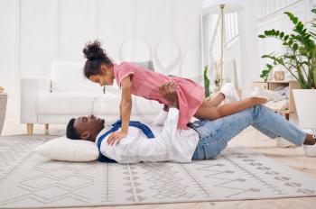 Happy father and little daughter play in living room.Dad and female child leisures in their house together, good relationship