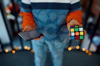 Young boy shows puzzle cube in his hands. Toy for brain and logical mind training, creative game, solving of complex problems