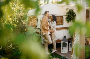 Love couple embraces in rv, camping in a trailer. Man and woman travels on van, romantic vacations on motorhome, campers leisures in camping-car