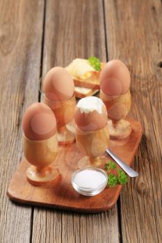 Boiled eggs in wooden eggcups and toast