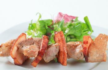 Pork skewer with mixed salad greens 