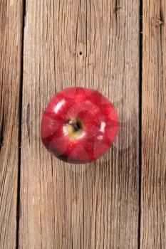 Shiny red apple on wood - overhead