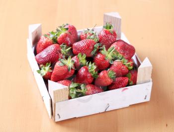 Fresh strawberries in a wooden crate - closeup