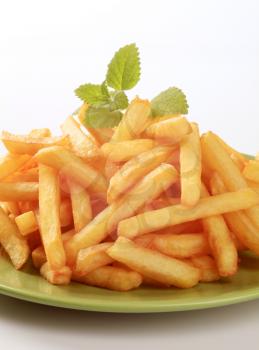 Heap of French fries  on a green plate