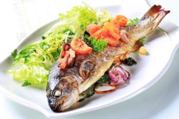 Herb-stuffed trout with tomatoes and green salad