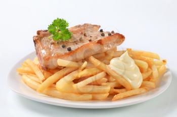 Pan seared pork chop with French fries and mayonnaise
