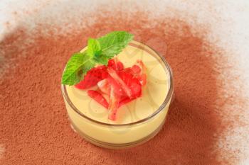 Small dish of custard topped with strawberry
