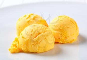 Scoops of yellow ice cream on a plate
