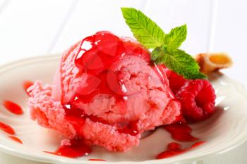 Scoop of pink ice cream with raspberry sauce