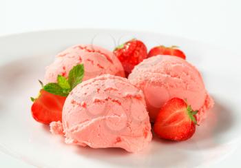 Scoops of strawberry ice cream and fresh strawberries