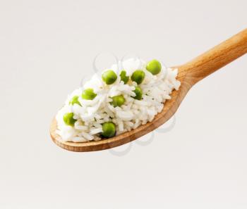 Rice and peas on a wooden spoon