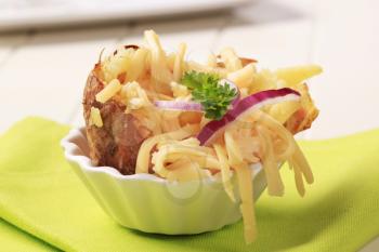 Baked potato sprinkled with grated edam cheese