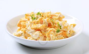 Plate of scrambled eggs sprinkled with fresh parsley