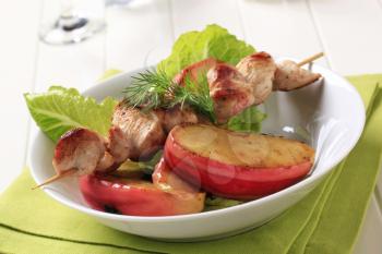 Chicken skewer with slices of baked apple