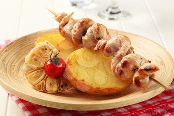 Chicken skewer on roasted potatoes - closeup