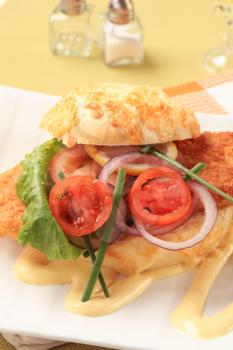 Fried fish sandwich with vegetable garnish and mayonnaise