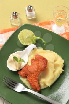 Fried breaded dinosaur-shaped nugget with potato puree