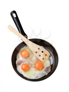 Preparing ham and eggs in a frying pan