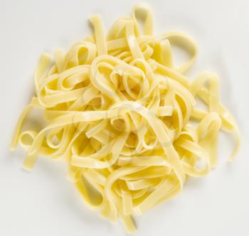 Ribbons of boiled pasta on white background