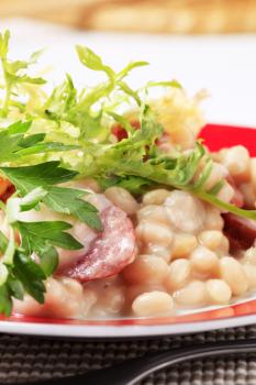 White beans with sausage garnished with salad greens