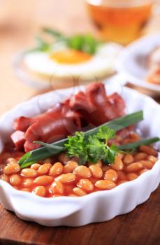 English breakfast of baked beans, sausages, fried egg and bacon