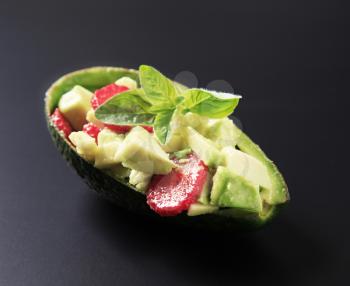 Avocado peel bowl filled with avocado and strawberry salad 