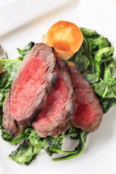 Slices of roast beef with sauteed spinach