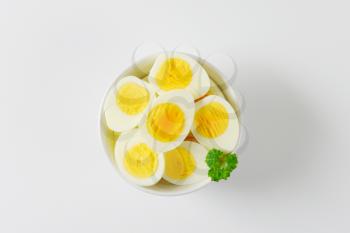 hard boiled egg halves in white bowl