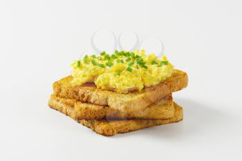 Scrambled eggs with chopped chives on toast