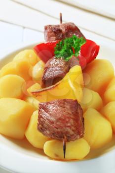 Grilled meat on skewer served with potatoes