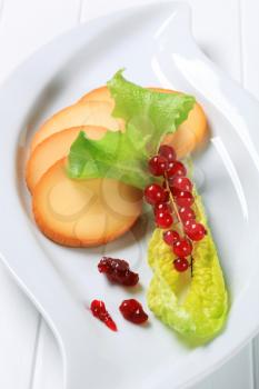 Slices of smoked cheese garnished with red currants