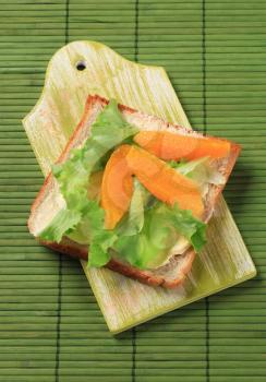 Sandwich bread with lettuce and wedges of orange