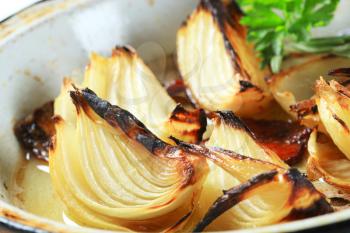 Pan roasted onion wedges on a frying pan