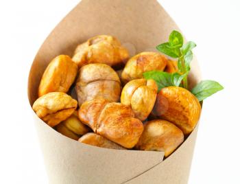 Peeled roasted chestnuts in a paper cone