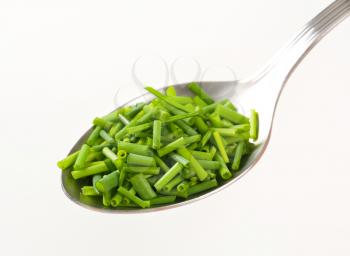 Chopped chives on a metal spoon