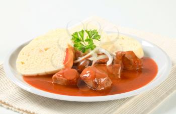 Pork meat in tomato sauce served with raised dumplings