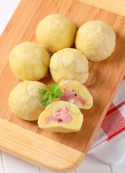 Meat stuffed potato dumplings on cutting board