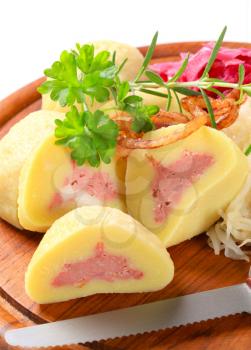 Meat stuffed potato dumplings with shredded cabbage on cutting board