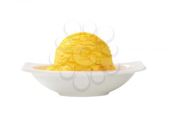 Scoop of yellow ice cream in white bowl