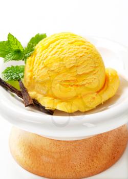 Scoop of yellow ice cream in a modern dessert dish